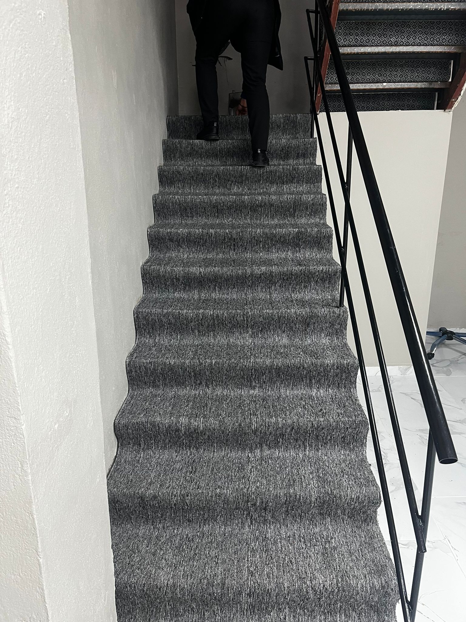 Merdiven basamakları ile sahanlığa uygulanmış gri halı